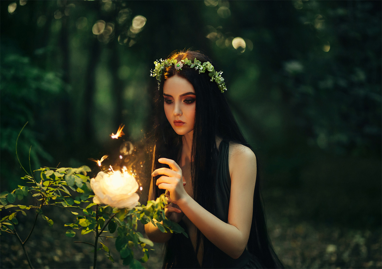 A beautiful woman is talking to fairies in the forest.