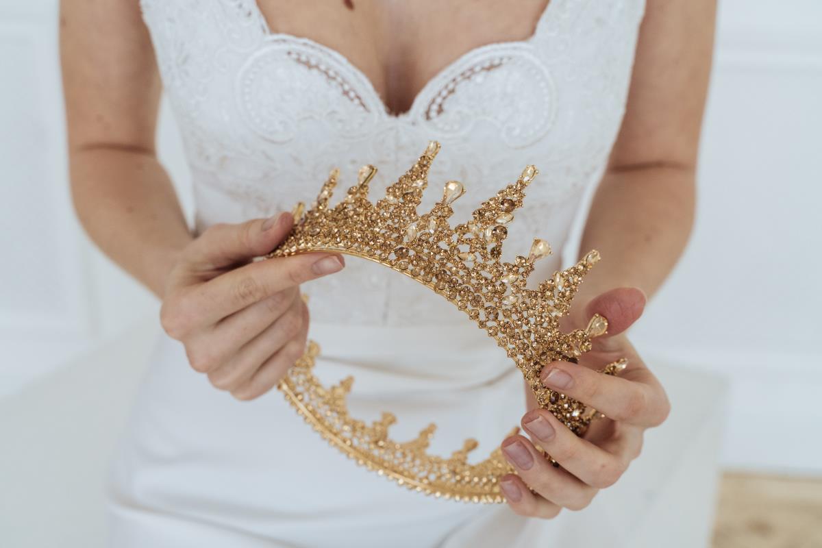 A bride is holding a crown in her hand.